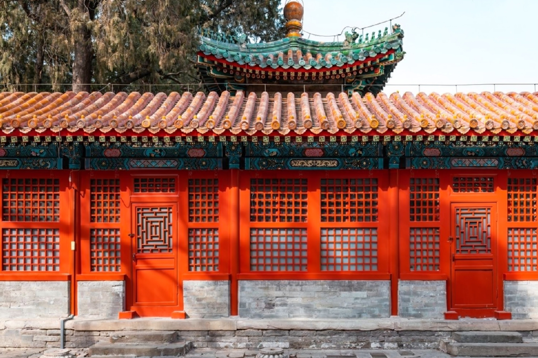 A tranquil pond in a Suzhou classical garden surrounded by pavilions, rockeries, and ancient trees