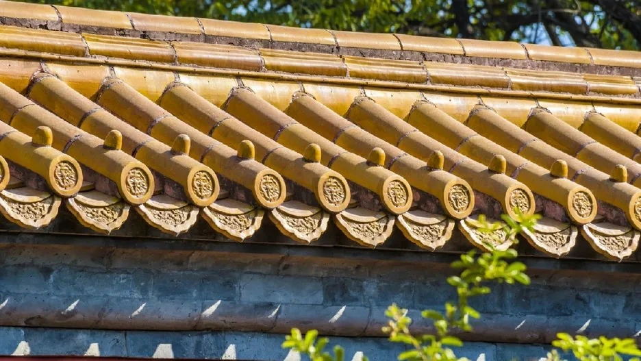 Vermillion red walls of a traditional Chinese palace glowing in afternoon light