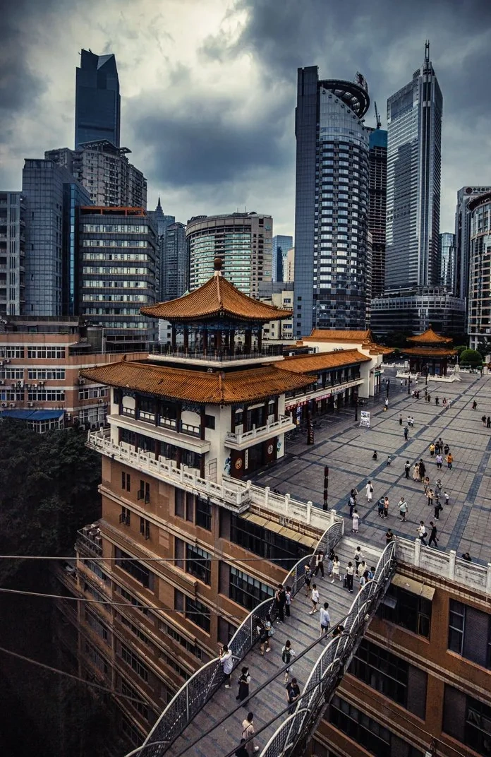 Chongqing's dramatic layered urban landscape with buildings stacked on hillsides, showcasing the Mountain City's unique three-dimensional geography