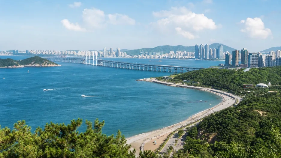Dalian's blue Xinghai Bay, coastal hills, beach, skyline and long bridge