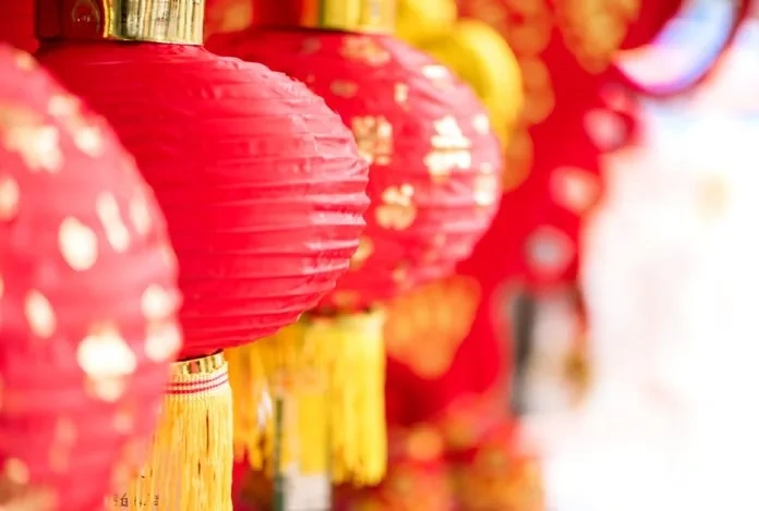 Hundreds of glowing red and gold lanterns floating in the night sky during the Lantern Festival